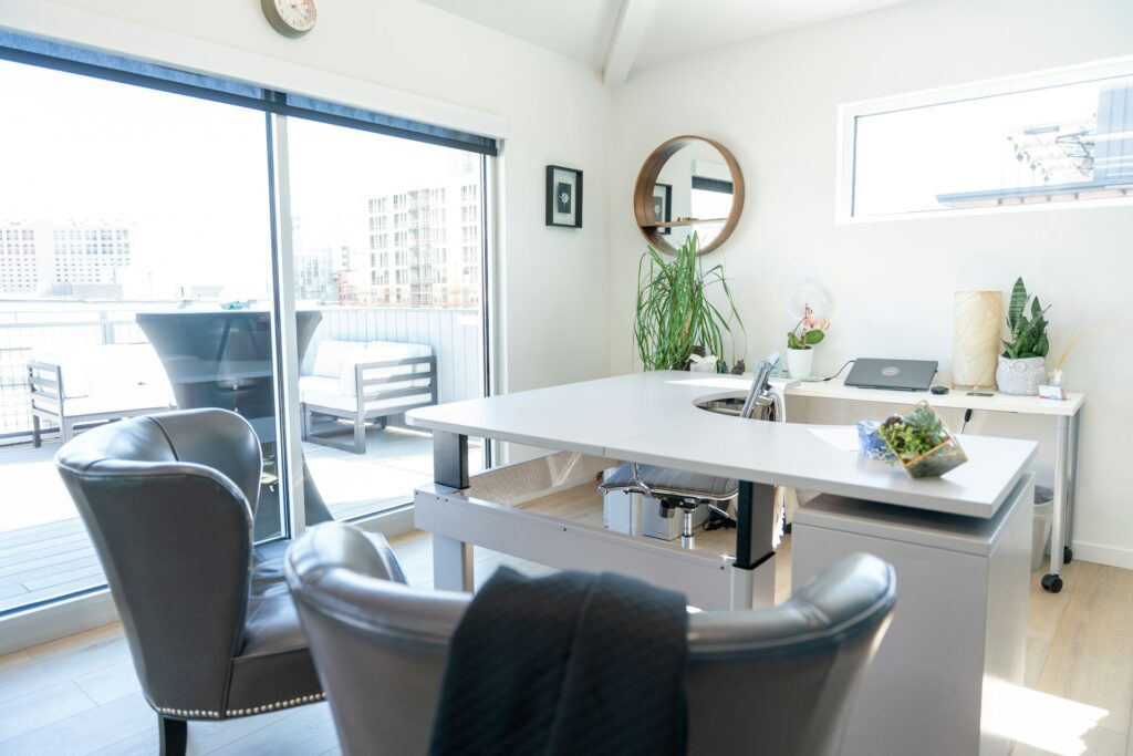 Large, beautiful, bright therapy office with a clean oversized desk and comfy client chairs