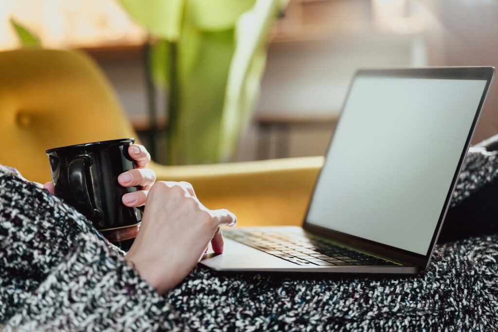 Relaxed therapist using a laptop while holding a cup of coffee